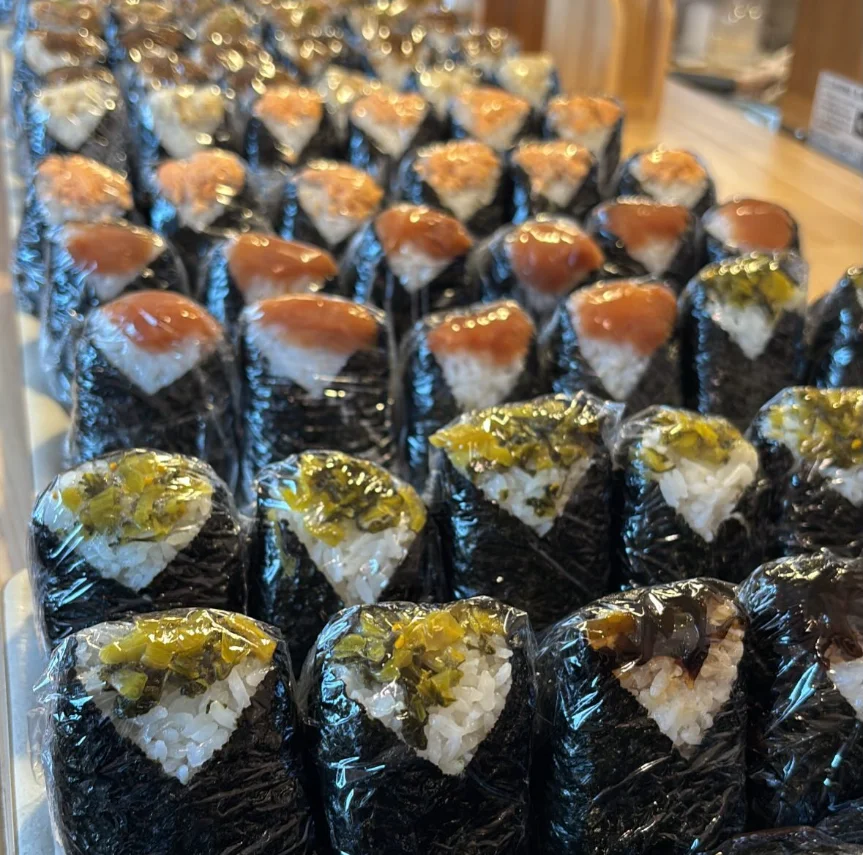 木の盆に二種類のおにぎりと味噌汁、小鉢を並べた湯気の立つ食事