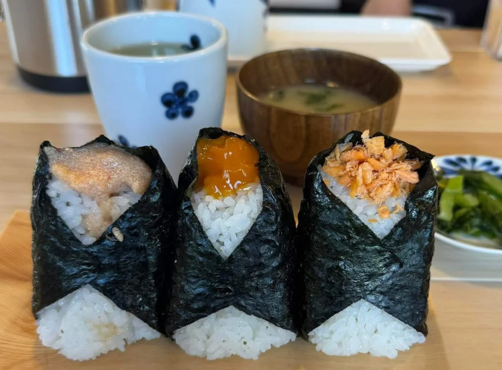 おにぎり二種と味噌汁、漬物を木の盆にまとめた昼の定食